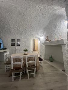 a white dining room with a table and chairs at Cuevas Halima in Bácor