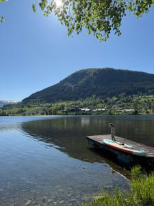 a person sitting on a paddle board on a dock on a lake at Simple Lakeside Anex - By the Water's Edge in Vossevangen +16 photos