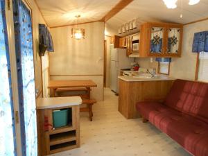 un soggiorno e una cucina con divano rosso in una roulotte. di O'Connell's RV Campground Park Model 34 a Inlet