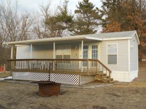 a small white house with a large deck at O'Connell's RV Campground Park Model 34 in Inlet