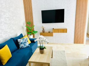 a living room with a blue couch and a tv at Casa Chic Studio Apartment in Casablanca