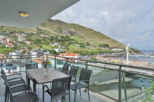 a balcony with a table and chairs and a view of the ocean at The Panoramic View Suites in Machico