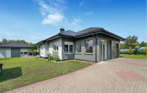 a house with a brick driveway in front of it at Amazing Home In Karlino in Karlino