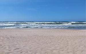 a sandy beach with the ocean in the background at Amazing Home In Karlino in Karlino