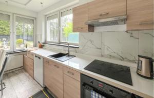 a kitchen with wooden cabinets and marble counter tops at Amazing Home In Karlino in Karlino
