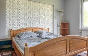 a bedroom with a wooden bed with a tufted headboard at Amazing Home In Karlino in Karlino