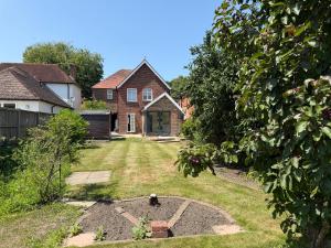 a yard with a house and a garden with a fire pit at Spacious 4-Bedroom Home in Liss
