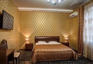 a bedroom with a bed and a chandelier at Frant Hotel in Volgograd
