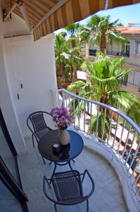 a balcony with a table and chairs and palm trees at Paraíso del Sol in Salobreña +46 photos