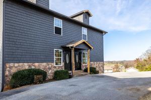 ピジョン・フォージにあるCozy Cabin Retreat w Arcade Hot Tub near Dollyの石壁の黒家