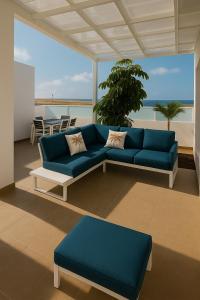 a living room with a blue couch and a table at Villa Ocean 8 by Dreaming Lanzarote Villas in Yaiza