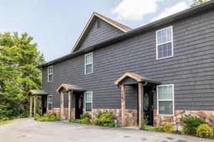 a house with black siding and a driveway at Comfortable Escape near Dolly w Hot Tub in Sevierville