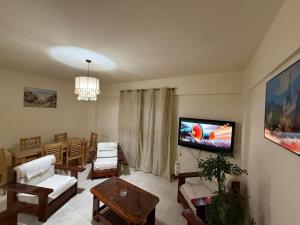 ein Wohnzimmer mit einem Flachbildfernseher an der Wand in der Unterkunft Villa in Marseille Beach 2 BOHO STYLE in El-Alamein