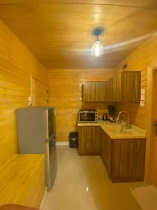 a kitchen with wooden cabinets and a refrigerator at كوخ خزامى الباحة in Al Baha +14 photos