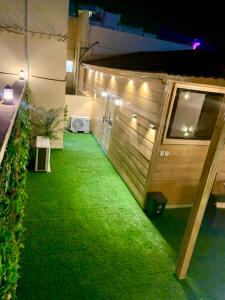 a small backyard with green grass and lights at كوخ خزامى الباحة in Al Baha