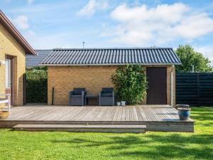 a wooden deck with two chairs on it in a yard at 4 person holiday home in Bredebro-By Traum in Bredebro