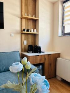 a living room with a couch and a vase with flowers at TASY Guest House - Luxury Rooms in the Heart od SHIROK SOKAK in Bitola