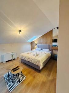 Un dormitorio con una cama grande y una mesa. en TASY Guest House, en Bitola