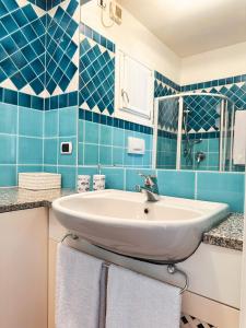 a bathroom with a sink and blue tiles at Casa Bonita Vista Porto in Santa Teresa Gallura