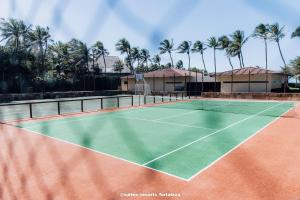 - un court de tennis en face d'une maison avec des palmiers dans l'établissement Apartamento - Pé na areia - Ao lado do parque aquático - Administrado por Anfitrião, à Aquiraz