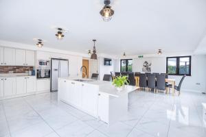 a kitchen with white cabinets and a table and chairs at Farm House Manor Luxury 8 bedrooms & 7 bathrooms Farm House & 40 mins away from Tower in Little Bridgeford