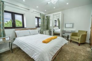 a bedroom with a bed with a yellow towel on it at Farm House Manor Luxury 8 bedrooms & 7 bathrooms Farm House & 40 mins away from Tower in Little Bridgeford