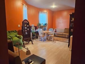 a living room with orange walls and a table and chairs at 5430 Happy Home in Chicago