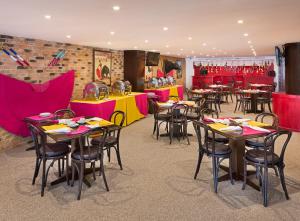 ein Restaurant mit Tischen und Stühlen in Rot und Gelb in der Unterkunft Hotel Francia Aguascalientes in Aguascalientes