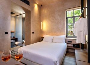 a bedroom with a bed and two glasses of wine at Nearchou Boutique Hotel in Chania
