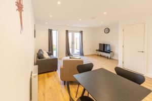 a living room with a table and chairs and a television at Joyful Management - A Mordern Semi-Detached House with 3 bedroom in Manchester