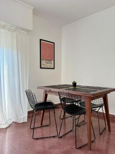a dining room table with two chairs and a table at Luminoso Depto al frente en el corazón del barrio Meridiano V- Meridiano Alquiler Temporario in La Plata