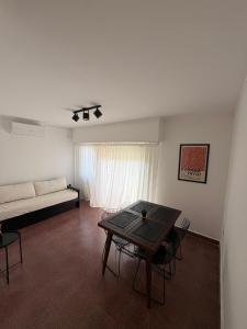 a living room with a couch and a table at Luminoso Depto al frente en el corazón del barrio Meridiano V- Meridiano Alquiler Temporario in La Plata +5 photos