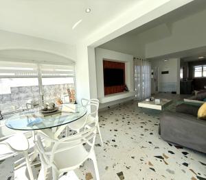 a living room with a glass table and chairs at Villa Stay & Enjoy in Antigua
