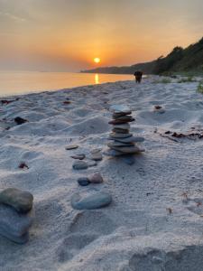 阿纳格Anno 1782 Unique Romantic Glamping at the Manors Historic Barn的日落时分，海滩上的一组岩石