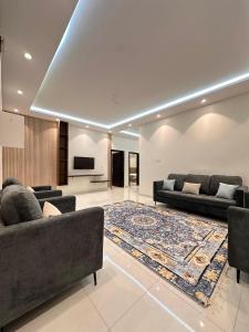 a living room with two couches and a rug at شقق اطلالة الضباب الباحه in Al Baha