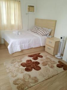 ein Schlafzimmer mit einem Bett und einem Teppich auf dem Boden in der Unterkunft Apple One Banawa Heights in Cebu City