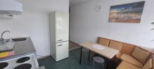 een kleine keuken met een tafel en stoelen en een wastafel bij Arzberger Monteurapartment in Arzberg