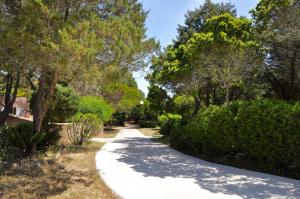 un camino a través de un parque con árboles y arbustos en Domaine Bocca di Feno, en Bonifacio