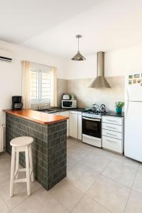 a kitchen with white appliances and a brick wall at Alojamiento H346 in Tandil