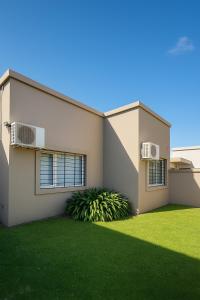 a house with a green lawn in front of it at Alojamiento H346 in Tandil