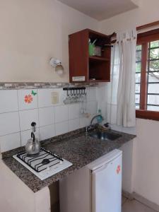 a kitchen with a sink and a stove top oven at APART HOTEl ACUARELA in Mina Clavero