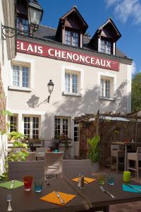 un restaurante con una mesa frente a un edificio en Logis Hôtels Restaurant Le Relais Chenonceaux, en Chenonceaux