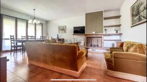 a living room with couches and a kitchen and a dining room at Villa Nice 800m dal mare in Marina di Pietrasanta