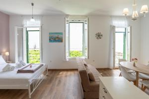 a living room with a bed and a couch and windows at Petra Sea View Oasis in Petra