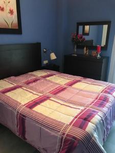 a bed with a colorful comforter in a bedroom at ISLANTILLA - URB GREEN 7 in Islantilla