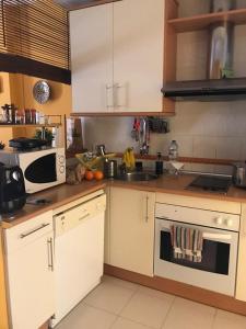 a kitchen with white cabinets and a sink at ISLANTILLA - URB GREEN 7 in Islantilla