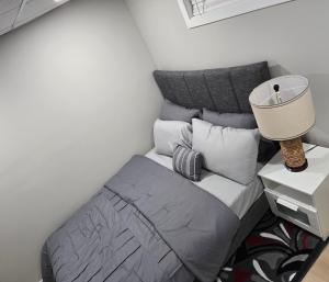 a bedroom with a bed with a lamp and pillows at Cozy 2 bedroom basement with side entrance in Bélanger +4 photos