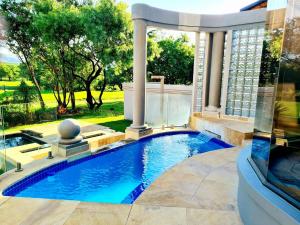 Una piscina en un patio trasero con un cenador. en The Villa Luxe Hartbeespoort Golf and Wildlife Estate, en Hartbeespoort 77 fotos más