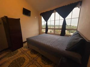 a bedroom with a bed and a large window at El Balcón de Ataco in Concepción de Ataco +41 photos