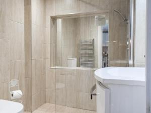 a bathroom with a toilet and a sink and a mirror at The Library Suite in Penn
